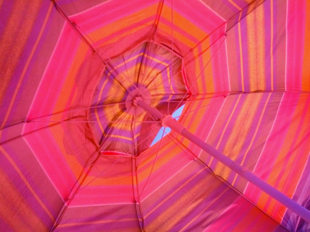 Sonnenschirm mit Schirmvorhang auf dem Strand